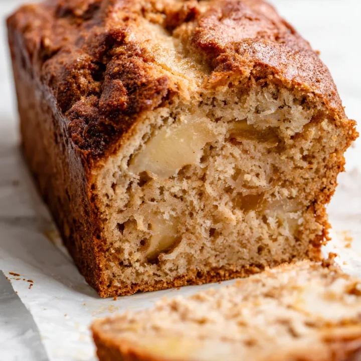 Ultra close-up of stacked slices of cinnamon apple bread showing caramelized crust and baked apple chunks